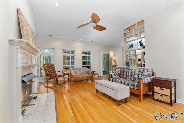 living room featuring a textured ceiling, ceiling fan, and hardwood / wood-style flooring