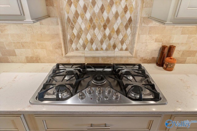 room details featuring gas cooktop, gray cabinets, and backsplash