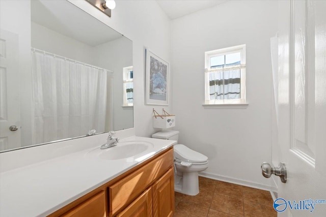 bathroom with toilet, vanity, and tile patterned flooring