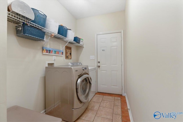 laundry area featuring washing machine and clothes dryer and light tile patterned floors