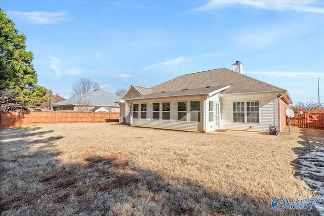 rear view of house featuring a yard