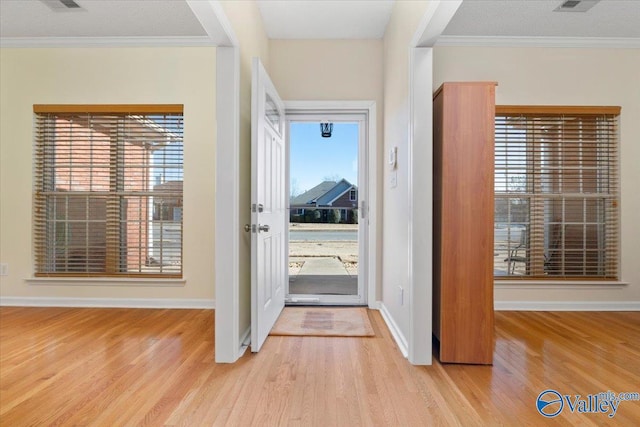 entryway featuring ornamental molding, light hardwood / wood-style flooring, and plenty of natural light