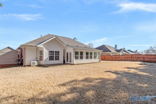 back of house with ac unit and a lawn