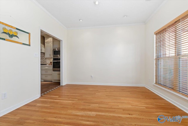 empty room featuring ornamental molding and light wood-type flooring