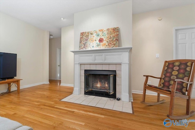 interior space with a tiled fireplace and light hardwood / wood-style flooring