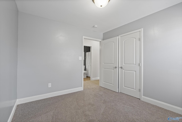 unfurnished bedroom with light colored carpet and a closet