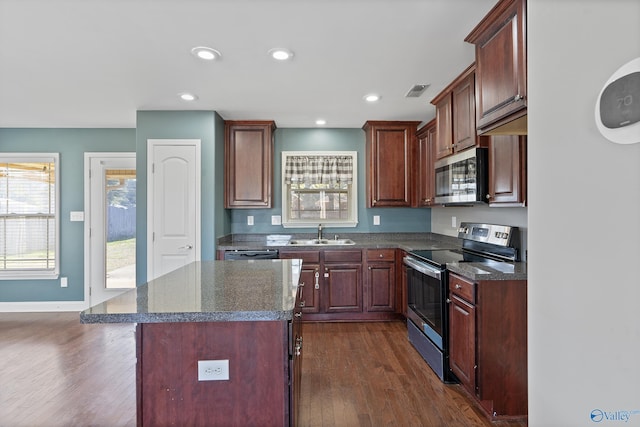 kitchen with dark hardwood / wood-style floors, sink, stainless steel appliances, and a center island