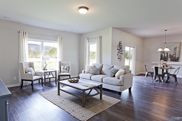 living area featuring dark wood-style flooring, plenty of natural light, and visible vents