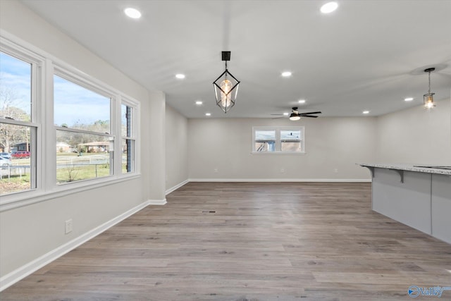 interior space featuring light wood-style flooring, baseboards, a ceiling fan, and recessed lighting