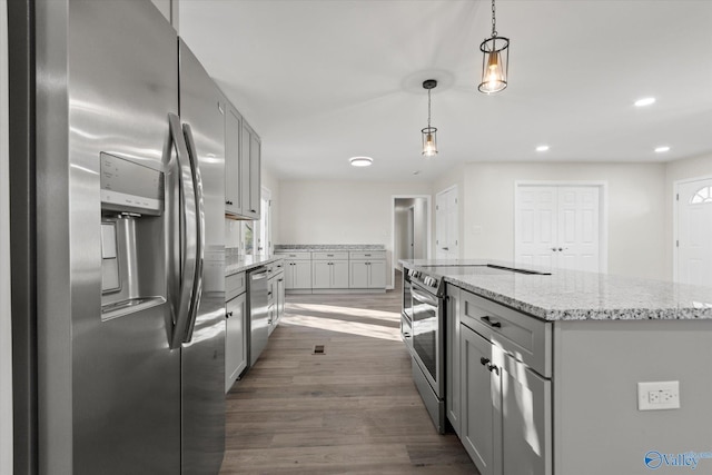 kitchen featuring appliances with stainless steel finishes, gray cabinets, dark wood finished floors, and light stone countertops