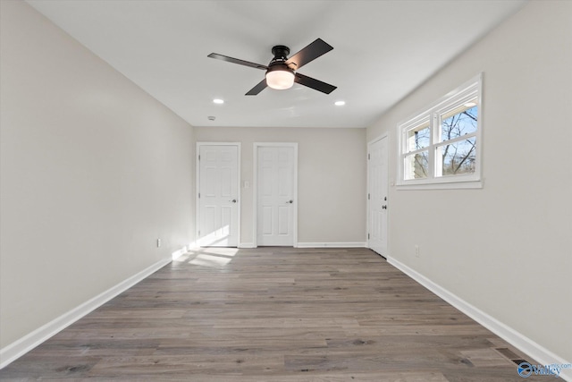 empty room featuring recessed lighting, wood finished floors, a ceiling fan, and baseboards