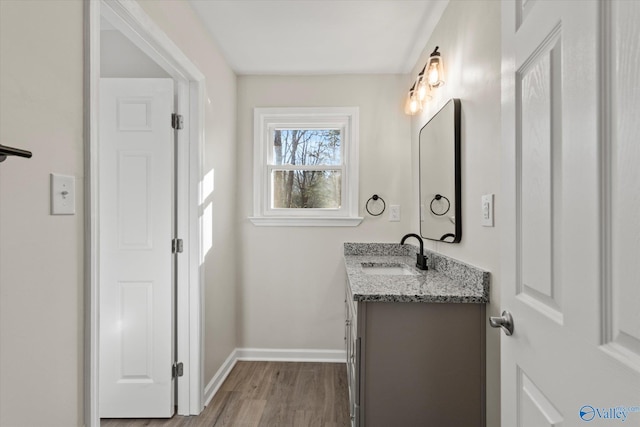 bathroom featuring vanity, baseboards, and wood finished floors