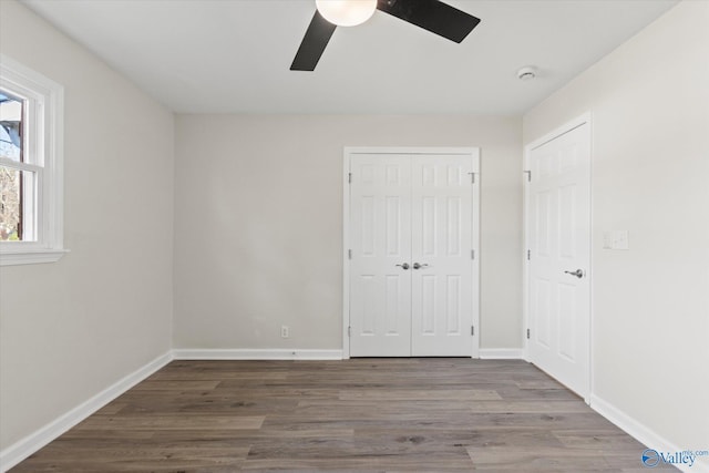 unfurnished bedroom with a ceiling fan, a closet, baseboards, and wood finished floors