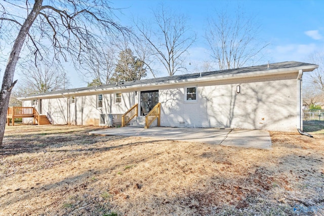 back of property with entry steps, brick siding, and a patio area