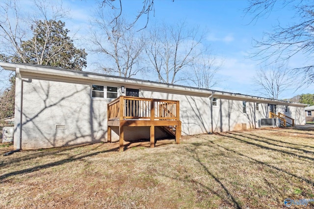 back of house featuring a yard, brick siding, crawl space, and a wooden deck