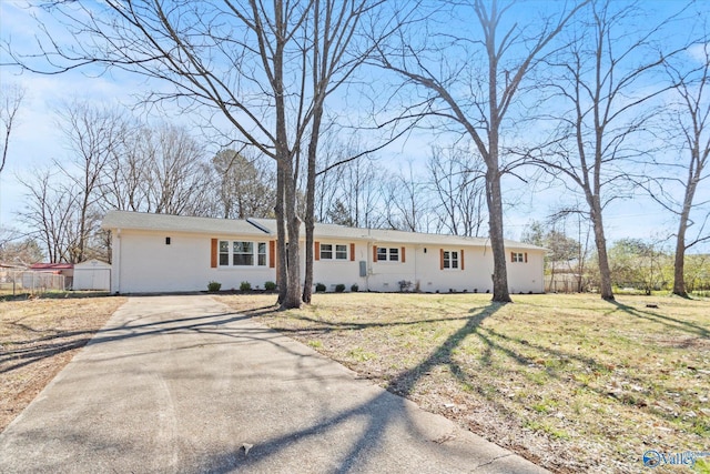 ranch-style house with driveway, a front lawn, fence, and brick siding