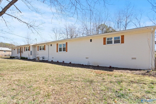 view of front of property with crawl space, a front yard, and brick siding