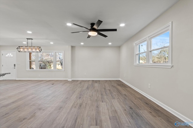 unfurnished living room featuring baseboards, ceiling fan, recessed lighting, and light wood-style floors