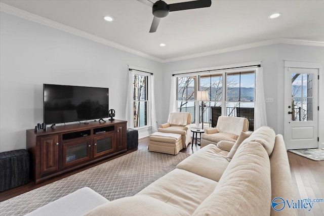 living room featuring hardwood / wood-style floors, crown molding, and ceiling fan