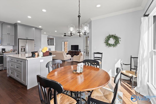 dining space featuring crown molding, a chandelier, and dark hardwood / wood-style flooring