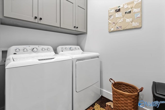 laundry room featuring washer and dryer and cabinets