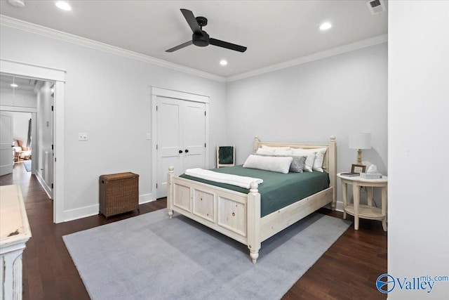 bedroom featuring dark hardwood / wood-style flooring, ornamental molding, ceiling fan, and a closet