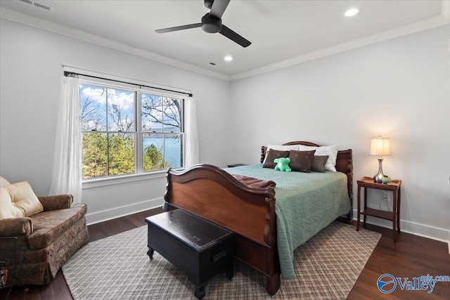 bedroom with dark hardwood / wood-style flooring, crown molding, and ceiling fan