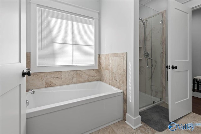 bathroom featuring shower with separate bathtub