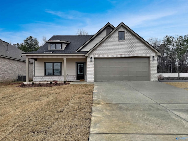 view of front of home featuring a garage, a front lawn, and covered porch