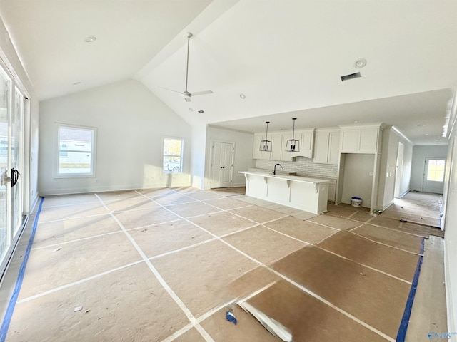 interior space featuring lofted ceiling, a healthy amount of sunlight, sink, and ceiling fan