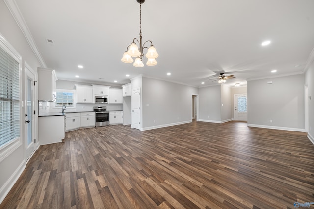 unfurnished living room featuring ceiling fan with notable chandelier, recessed lighting, plenty of natural light, and dark wood-style floors