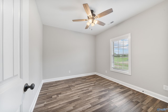 spare room with visible vents, baseboards, a ceiling fan, and dark wood finished floors