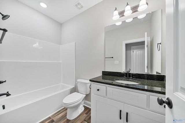 bathroom featuring visible vents, toilet, bathtub / shower combination, vanity, and wood finished floors
