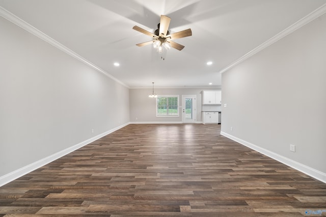 unfurnished living room with dark wood-style flooring, baseboards, and crown molding
