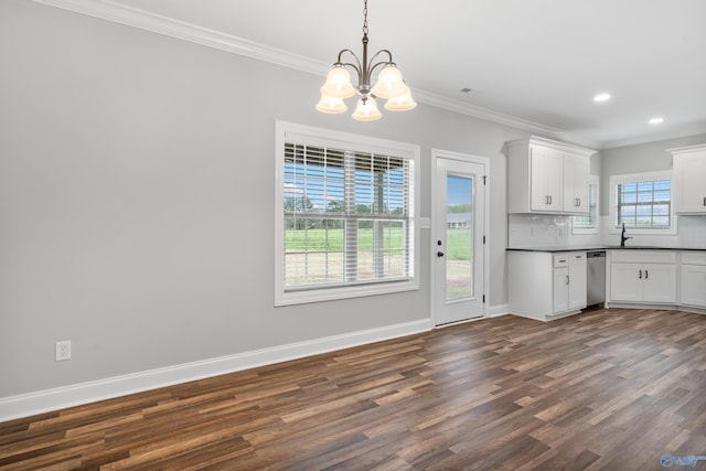 kitchen featuring crown molding, stainless steel dishwasher, dark wood-type flooring, dark countertops, and a notable chandelier