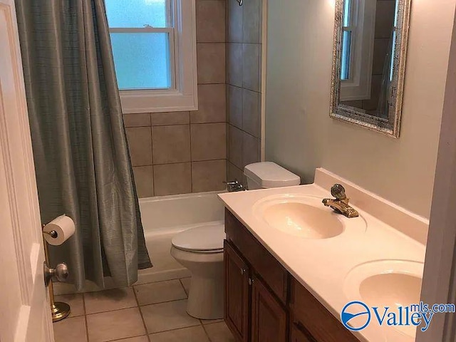 full bathroom featuring double vanity, shower / bath combination with curtain, tile patterned flooring, a sink, and toilet