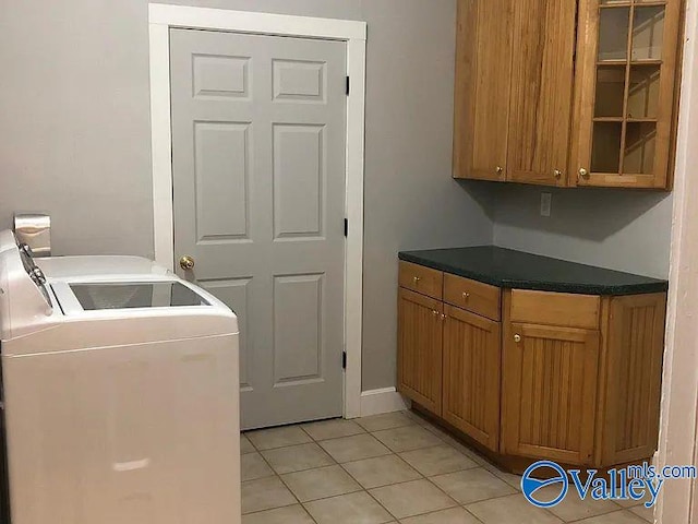 laundry room with cabinet space, separate washer and dryer, and light tile patterned floors