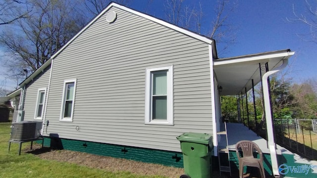 view of side of home with central AC unit, fence, and crawl space