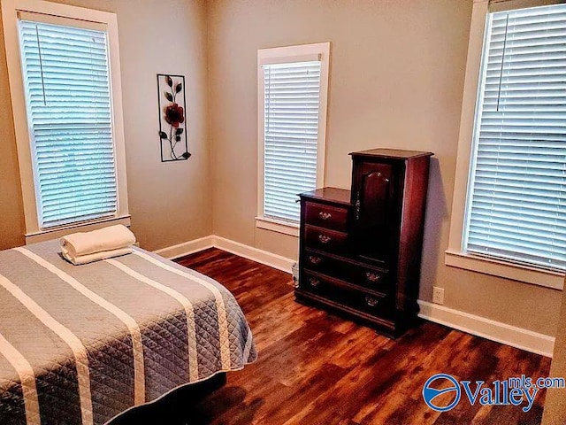 bedroom featuring baseboards and dark wood finished floors