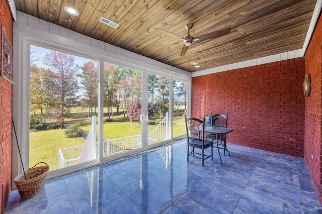 unfurnished sunroom featuring ceiling fan and wooden ceiling