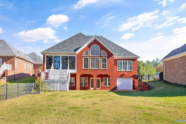 rear view of house with a sunroom, a garage, and a yard