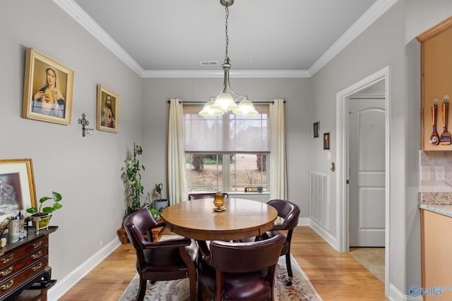 dining area featuring light wood-style flooring, visible vents, and ornamental molding