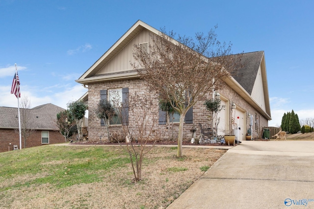 view of front of house with roof with shingles, a front lawn, driveway, brick siding, and board and batten siding