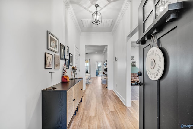 corridor with a chandelier, ornamental molding, and light hardwood / wood-style flooring