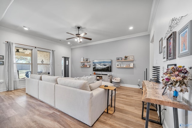 living room with ornamental molding, ceiling fan, and light hardwood / wood-style floors