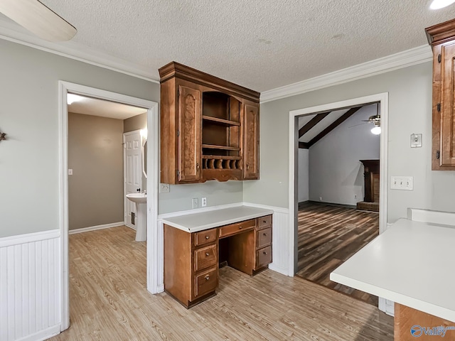 kitchen with ceiling fan, a textured ceiling, and light hardwood / wood-style flooring