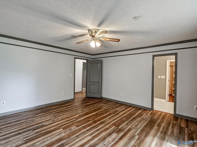 unfurnished bedroom with ceiling fan, ornamental molding, a textured ceiling, and dark wood-type flooring