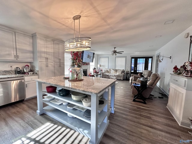 kitchen with stainless steel dishwasher, light stone counters, ceiling fan, decorative light fixtures, and white cabinets