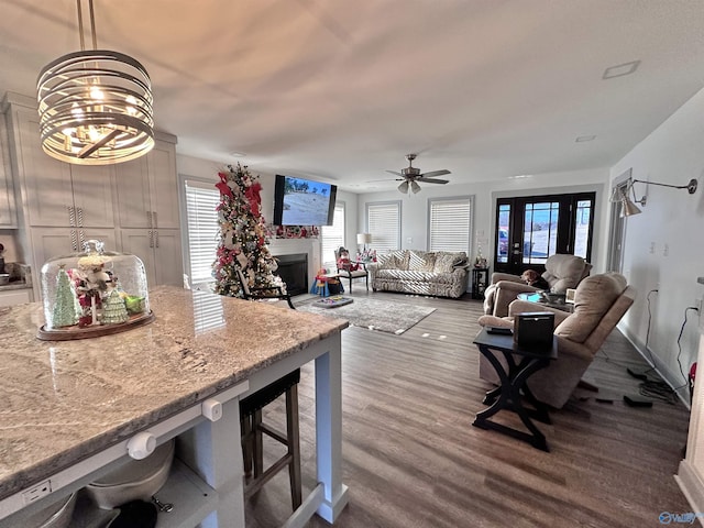 interior space with ceiling fan with notable chandelier and hardwood / wood-style flooring