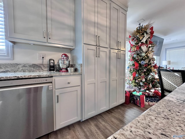 kitchen with light stone countertops, dishwasher, and dark hardwood / wood-style floors